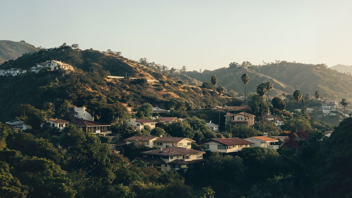 Houses scattered across a green hillside at dusk